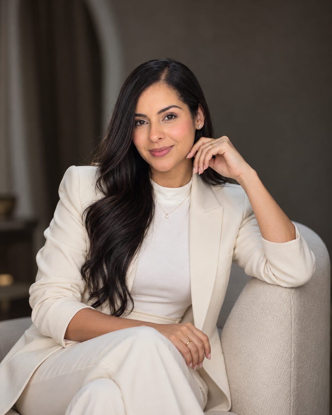 Retrato de Giselle Pérez, sentada con un traje color crema